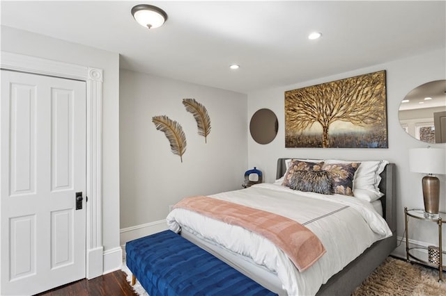 bedroom with recessed lighting, baseboards, arched walkways, and wood finished floors