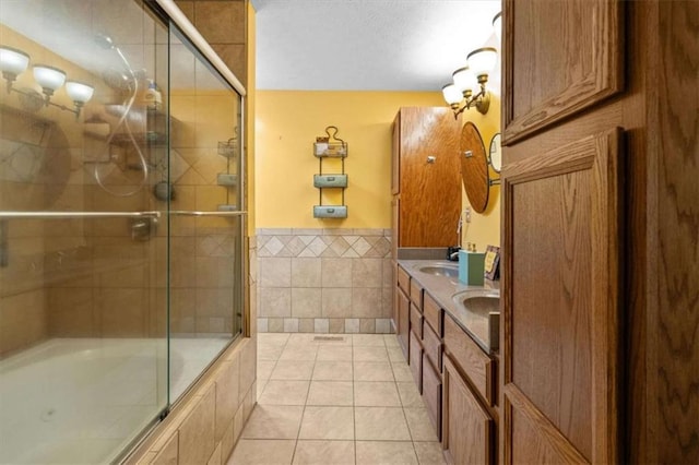 75 Mcpherson Ln, Bremen, GA 30110 - bathroom featuring tile walls, tile patterned floors, double vanity, a wainscoted wall, and tiled shower / bath