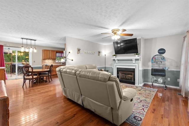 75 Mcpherson Ln, Bremen, GA 30110 - living area featuring a ceiling fan, light wood-type flooring, a fireplace, and a textured ceiling