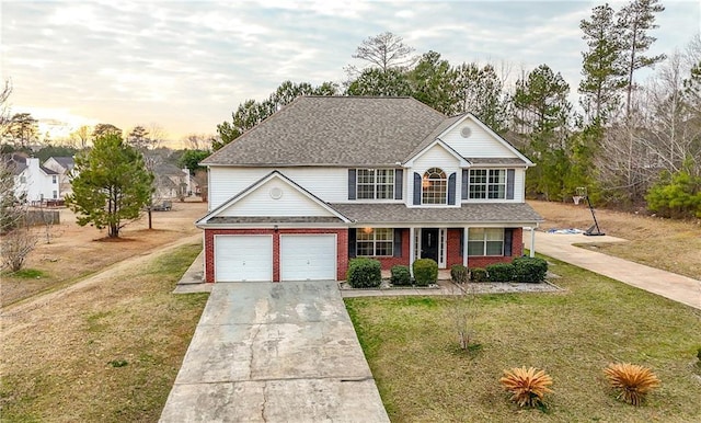 view of front of property featuring a garage, covered porch, and a lawn