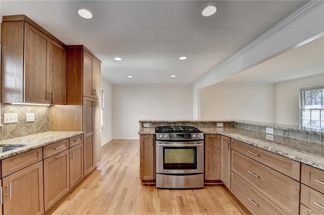 kitchen featuring light stone counters, stainless steel range with gas cooktop, and light hardwood / wood-style floors