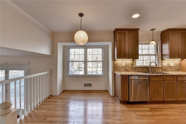 kitchen with sink, light hardwood / wood-style flooring, dishwasher, hanging light fixtures, and light stone countertops