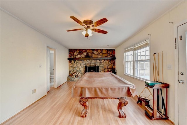 game room with crown molding, pool table, light hardwood / wood-style flooring, ceiling fan, and a fireplace