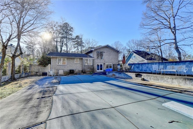 back of property featuring a covered pool and a patio area