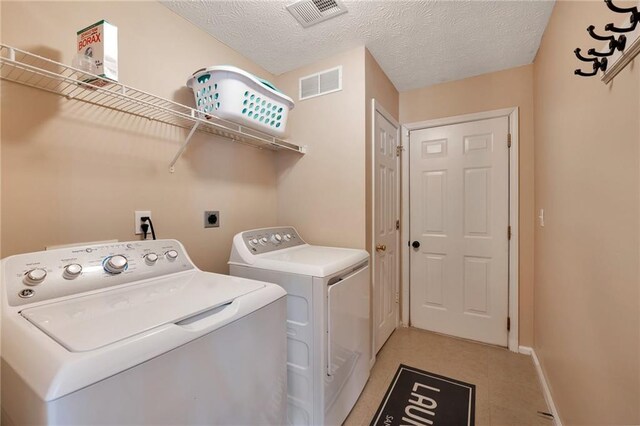 washroom featuring washer and clothes dryer and a textured ceiling