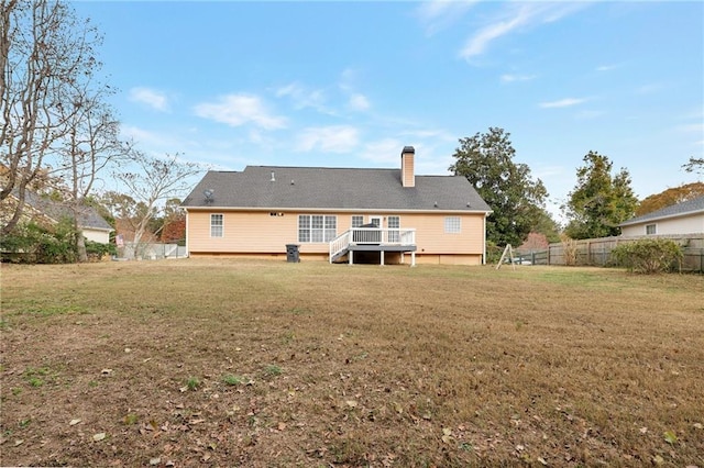 rear view of property with a deck and a lawn