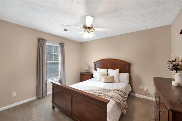 carpeted bedroom with a textured ceiling and ceiling fan