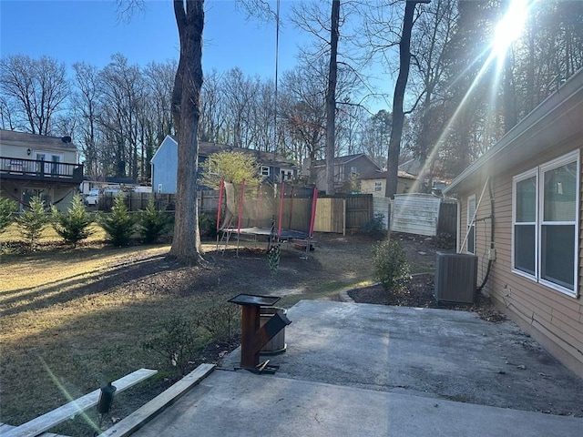 view of yard with central AC, a patio, and a trampoline