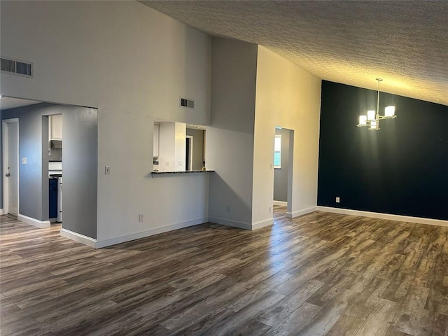 unfurnished living room featuring high vaulted ceiling, dark wood-type flooring, a textured ceiling, and an inviting chandelier