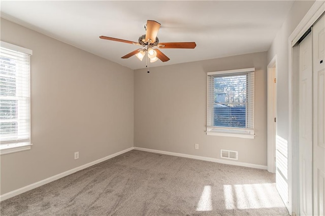 unfurnished room featuring light colored carpet and ceiling fan