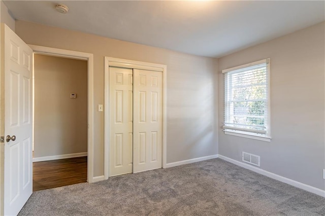 unfurnished bedroom featuring carpet flooring and a closet