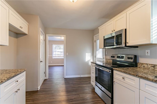 kitchen with white cabinetry, appliances with stainless steel finishes, dark hardwood / wood-style floors, and light stone counters