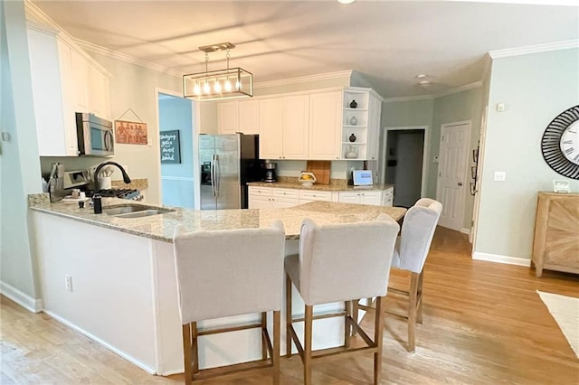 310 Hillpine Dr, Woodstock, GA 30189 - kitchen with stainless steel appliances, open shelves, white cabinets, a peninsula, and light wood finished floors