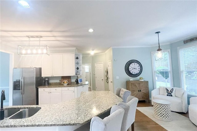 310 Hillpine Dr, Woodstock, GA 30189 - kitchen featuring stainless steel fridge, white cabinetry, a sink, light stone counters, and ornamental molding