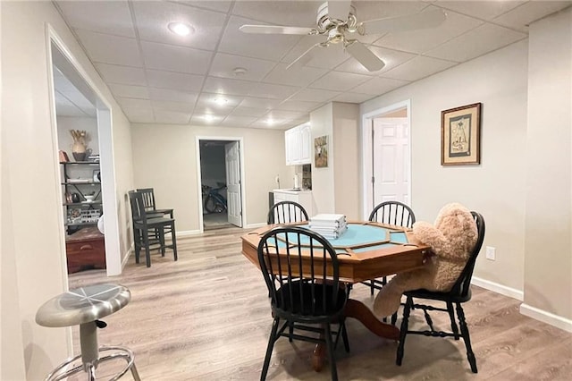 310 Hillpine Dr, Woodstock, GA 30189 - dining area featuring light wood finished floors, a paneled ceiling, baseboards, and ceiling fan