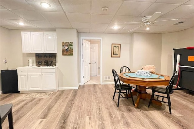 310 Hillpine Dr, Woodstock, GA 30189 - dining room featuring light wood-type flooring, ceiling fan, a paneled ceiling, and baseboards