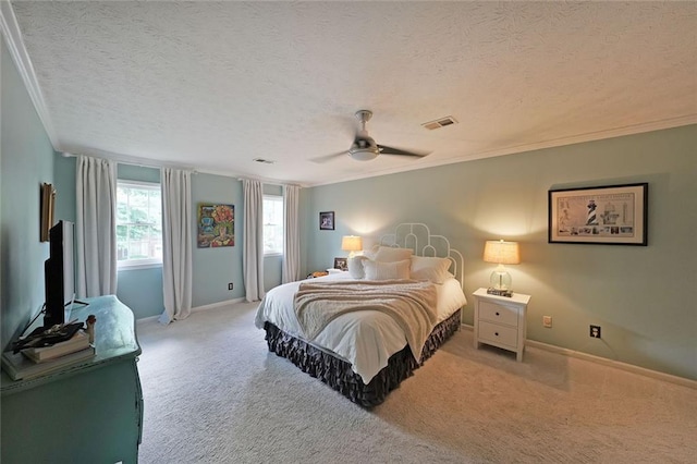 bedroom with ceiling fan, a textured ceiling, crown molding, carpet floors, and baseboards