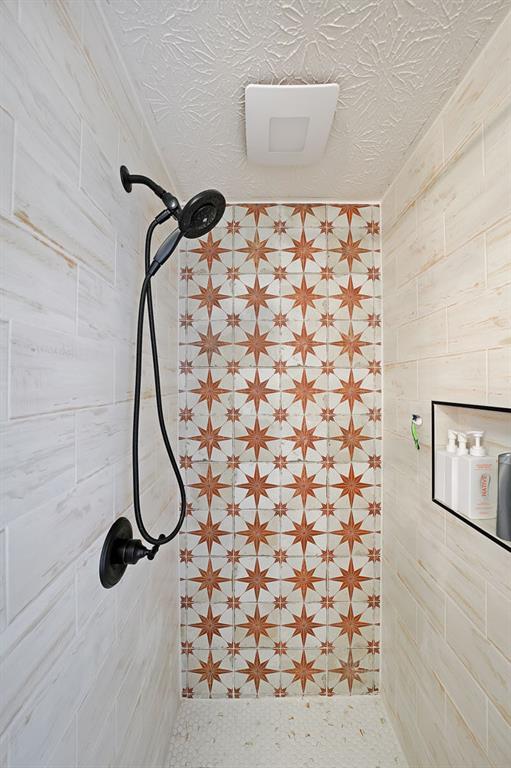 interior details featuring a tile shower