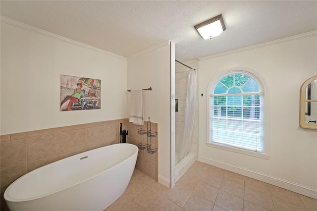 full bathroom featuring tile walls, ornamental molding, a shower with shower curtain, and a freestanding bath