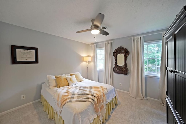 bedroom featuring light colored carpet, baseboards, and multiple windows