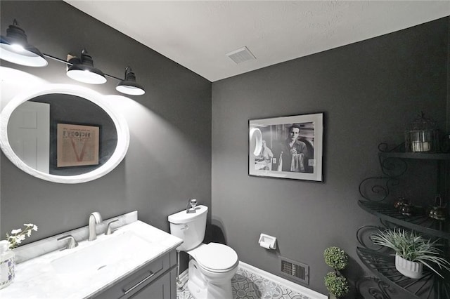 bathroom with vanity, baseboards, toilet, and visible vents