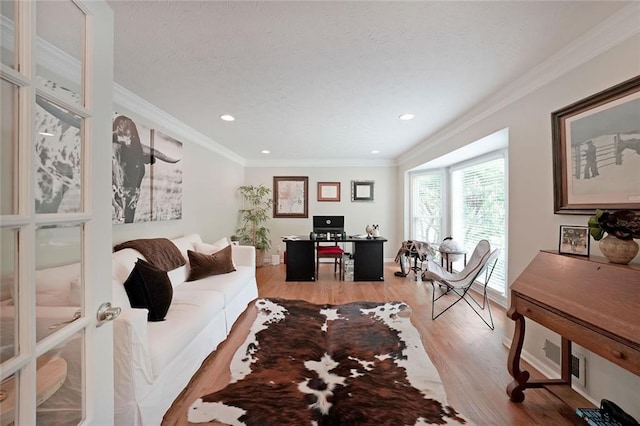 living area with recessed lighting, ornamental molding, light wood-style flooring, and baseboards