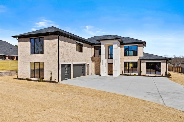 view of front of home with a garage, fence, and brick siding