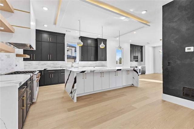 kitchen with a large island, light countertops, decorative light fixtures, and a kitchen breakfast bar