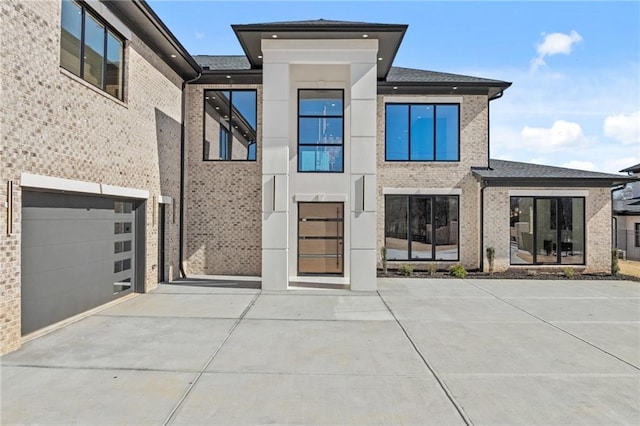 view of front of property with a garage, driveway, and brick siding