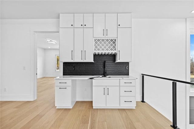 kitchen featuring white cabinets, light countertops, and a sink