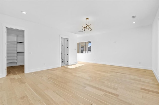 interior space featuring light wood-style floors, recessed lighting, a notable chandelier, and baseboards