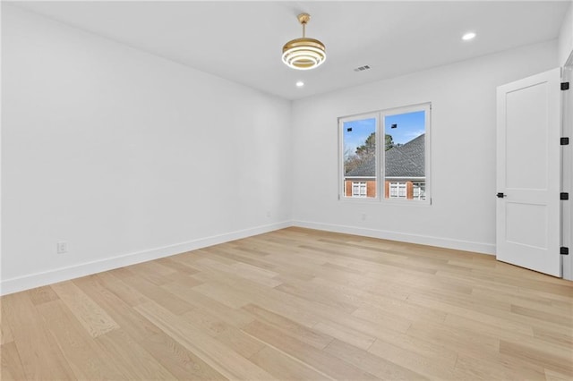 empty room featuring recessed lighting, visible vents, light wood-style flooring, and baseboards