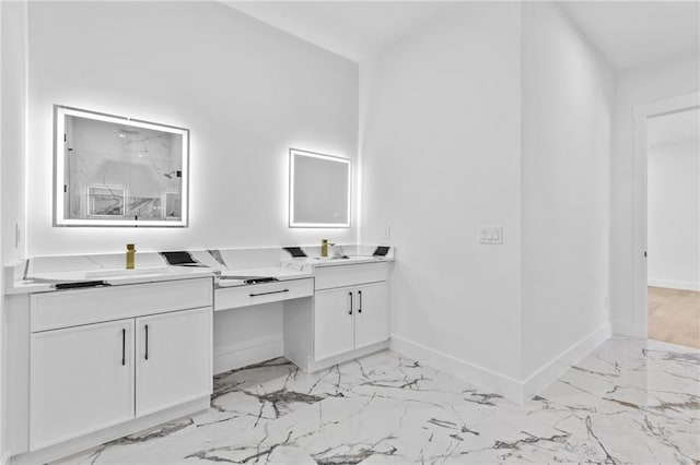 full bathroom with a marble finish shower, a sink, baseboards, and double vanity