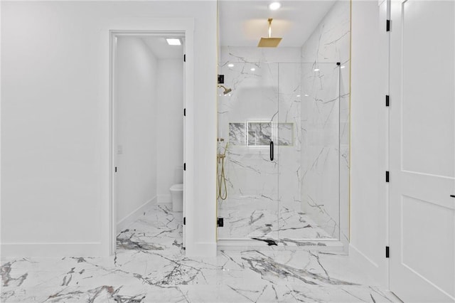 full bath with marble finish floor, a marble finish shower, toilet, and baseboards