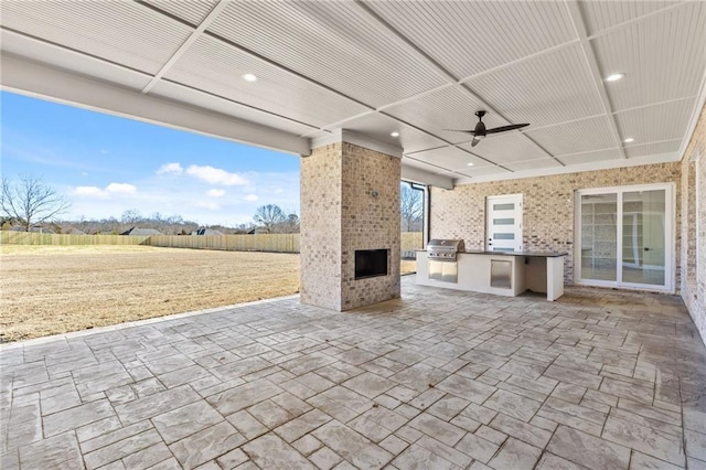 view of patio / terrace with ceiling fan, a fireplace, and area for grilling