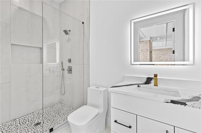 bathroom with toilet, a stall shower, and vanity