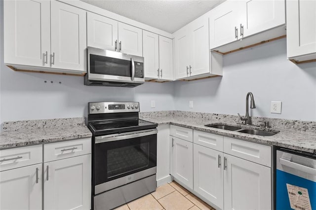 3626 Buford Hwy NE Unit C1, Brookhaven, GA 30329 - kitchen with stainless steel appliances, a sink, white cabinetry, light tile patterned floors, and a textured ceiling