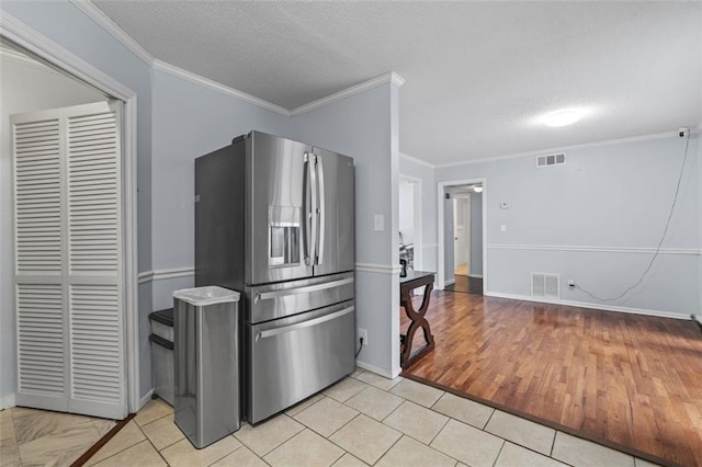 3626 Buford Hwy NE Unit C1, Brookhaven, GA 30329 - kitchen with stainless steel refrigerator with ice dispenser, ornamental molding, light tile patterned flooring, a textured ceiling, and baseboards