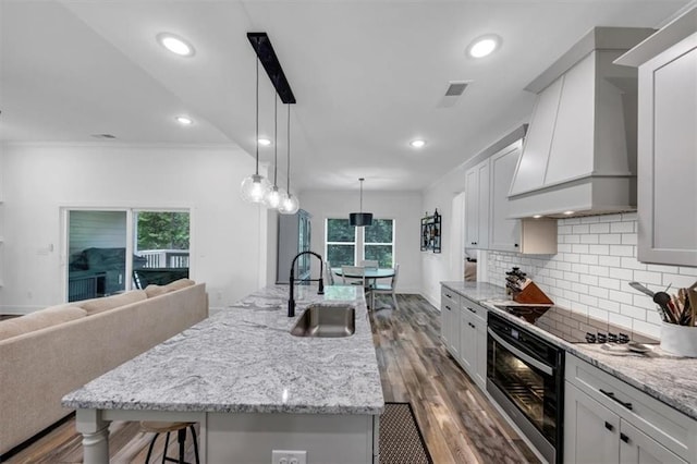 1021 Windsor Creek Dr, Madison, GA 30650 - kitchen with premium range hood, black range with electric cooktop, plenty of natural light, crown molding, and tasteful backsplash