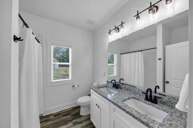 1021 Windsor Creek Dr, Madison, GA 30650 - bathroom with plenty of natural light, double vanity, wood finished floors, and a shower with curtain