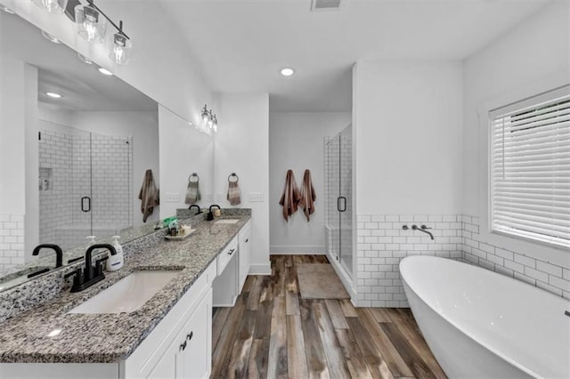 1021 Windsor Creek Dr, Madison, GA 30650 - bathroom with double vanity, a soaking tub, a shower stall, wood finished floors, and recessed lighting