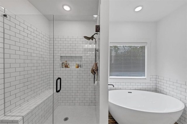 1021 Windsor Creek Dr, Madison, GA 30650 - full bath featuring a stall shower, a freestanding tub, recessed lighting, and tile walls