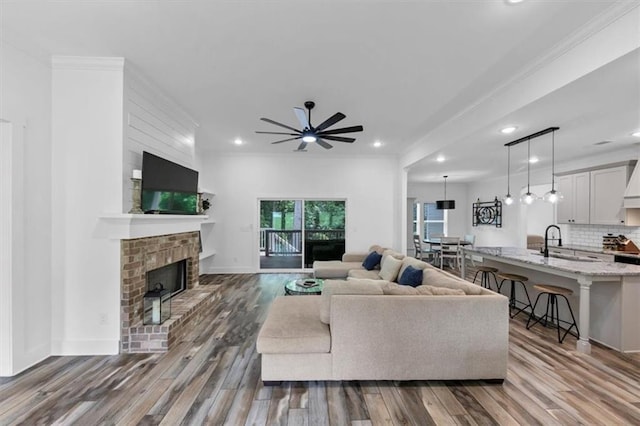 1021 Windsor Creek Dr, Madison, GA 30650 - living area featuring ceiling fan, ornamental molding, wood finished floors, a fireplace, and recessed lighting