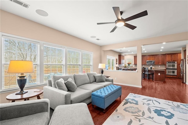 living room with ceiling fan and dark hardwood / wood-style flooring