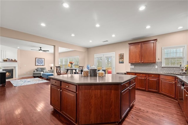 kitchen with stainless steel dishwasher, a center island, sink, and a wealth of natural light