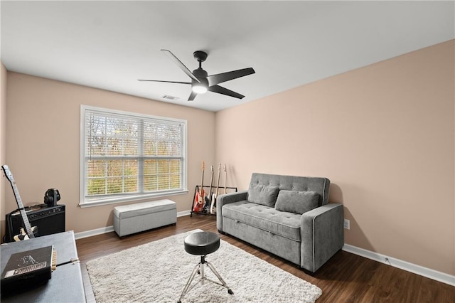 living area featuring dark wood-type flooring and ceiling fan