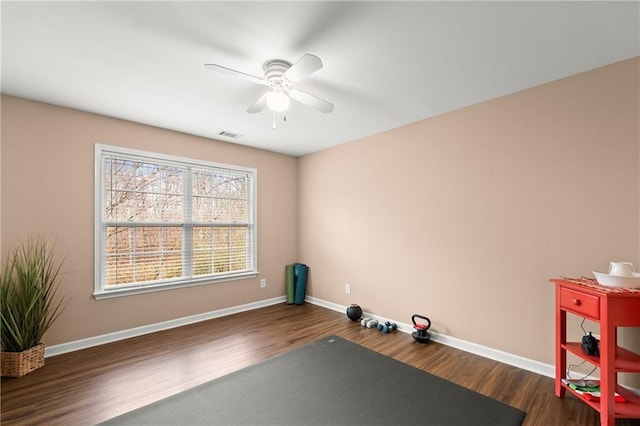 exercise area with dark hardwood / wood-style floors and ceiling fan