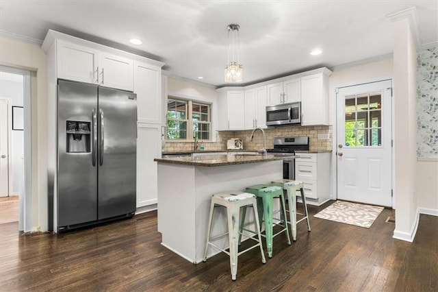 1630 Park Ln, Marietta, GA 30066 - kitchen with stainless steel appliances, healthy amount of natural light, dark wood-style floors, white cabinetry, and crown molding