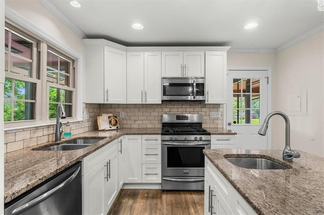 1630 Park Ln, Marietta, GA 30066 - kitchen with stainless steel appliances, a sink, ornamental molding, dark wood-type flooring, and light stone counters