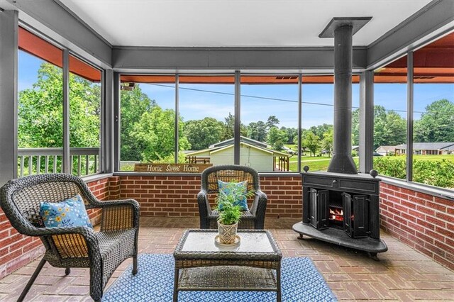 1630 Park Ln, Marietta, GA 30066 - sunroom with a wood stove, brick floors, view of wooded area, and brick wall